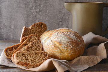 Fresh bread and jug on table