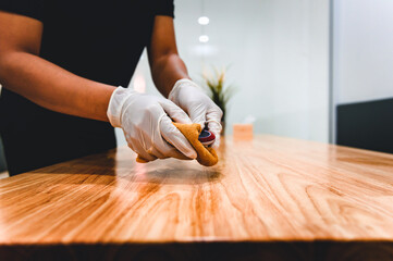 Hand of waiter woman cleaning table and equipment with microfiber cloth for disinfecting at indoor restaurant. Coronavirus prevention concept.