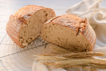 Loaf of sourdough bread on white wooden background