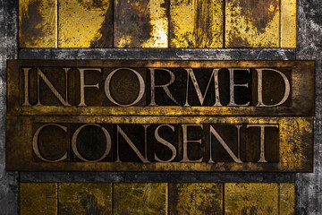 Informed Consent text formed with real authentic typeset letters on vintage textured silver grunge copper and gold background