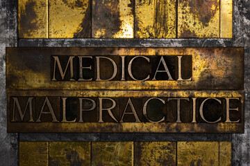 Medical Malpractice text formed with real authentic typeset letters on vintage textured silver grunge copper and gold background