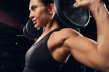 Determined young woman working out at the gym - obrazy, fototapety, plakaty