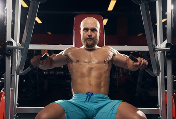 Strong sportsman doing exercises at the gym