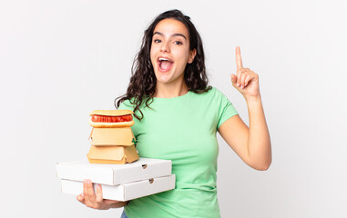 pretty hispanic woman feeling like a happy and excited genius after realizing an idea and holding...