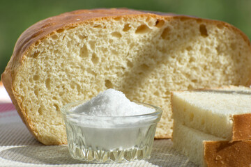 Homemade bread, slices of bread and salt on the table. Simple traditional food. Side view.