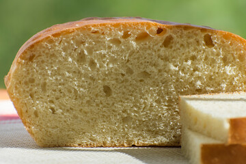 Fresh homemade bread and slices of bread on the table. Simple traditional food. Side view.