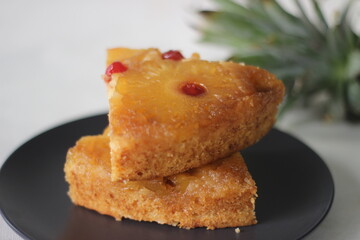 Slice of caramelised pineapple upside down cake. Home baked pineapple cake with pineapple slices are on the top