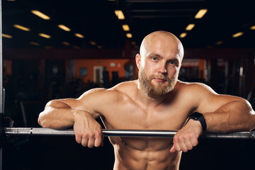 Muscular man standing shirtless at the gym