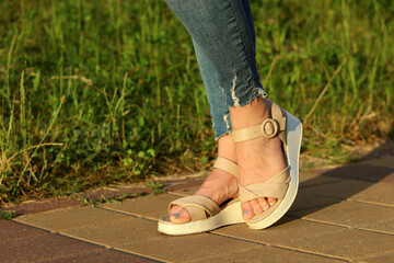 Feet in summer sandals flaunts in the sun