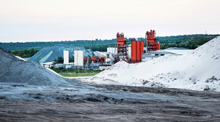 Asphalt plant with heaps of sand and gravel for the production of asphalt.