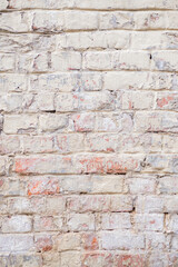 Vertical background with red brick wall with peeling plaster