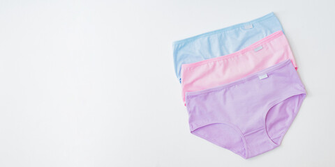 Flat lay set of women panties of different colors on a white background. Top view advertising and shopping concept