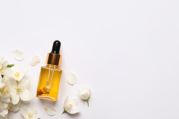 Jasmine essential and fresh flowers on white background, top view