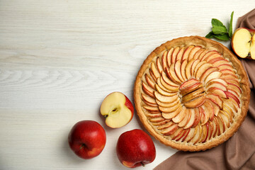 Delicious homemade apple tart and fresh fruits on white wooden table, flat lay. Space for text