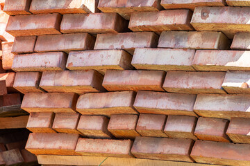 Lot of red ceramic bricks backdrop at construction, building site
