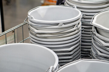 Lot of gray plastic buckets in stacks, in a hardware store