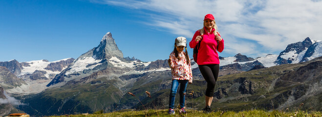 Happy hiker woman and girl at mountains lake