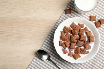 Bowl with tasty corn pads and milk on wooden table, flat lay. Space for text