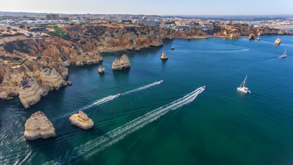 Aerial view of the beautiful paradise beaches of Camilo and Dona Anna, Lagos area. Tourist boats and ships entertain tourists on summer vacations.