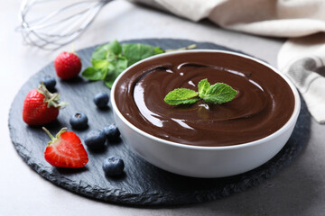 Delicious chocolate cream with berries and mint on table