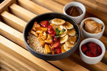 Healthy oatmeal with caramelized fruit: banana, strawberry and apple, top view, menu photography