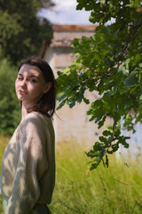 young woman in tall dry grass in a field in the midst of summer heat