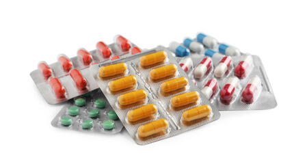 Pile of different pills in blister packs on white background