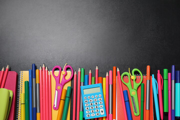 Flat lay composition with school stationery on black chalkboard, space for text