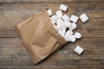 Delicious puffy marshmallows on wooden table, flat lay