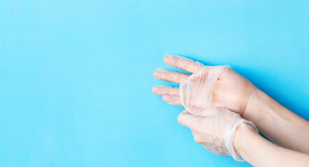 Banner with male hands removing transparent vinyl disposable gloves above blue background with copy space. Safety first concept