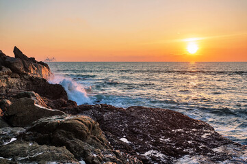 Beautiful sunset on the rock beach.