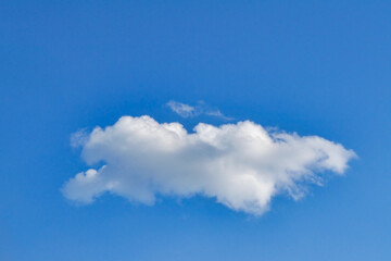 One single fluffy cloud isolated on clear sky background, sunny summer day.