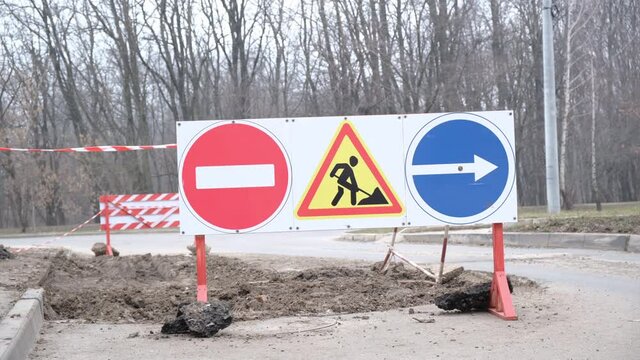 Close up of sign of road work to inform traffic participants about carrying out repairs on road. Concept of careful and attentive driving.Warning sign road repair, detour. Car traffic