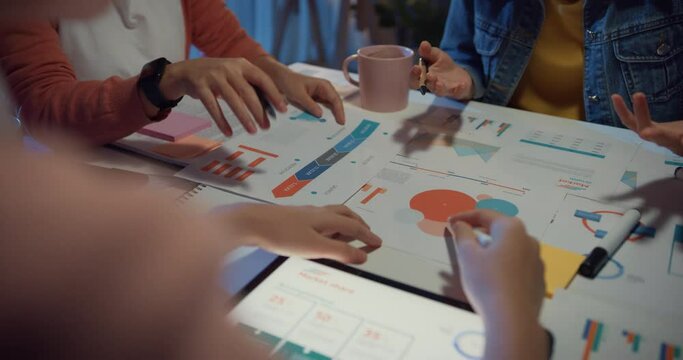 Close-up asia businesspeople meeting plan analysis statistics brainstorm and header of team hold tablet point graph chart and employee take note at home office night. Finance strategy success concept.