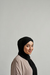 Portrait of happy young arabic woman in black hijab