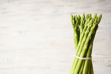 Fresh asparagus on wooden background, place for text.