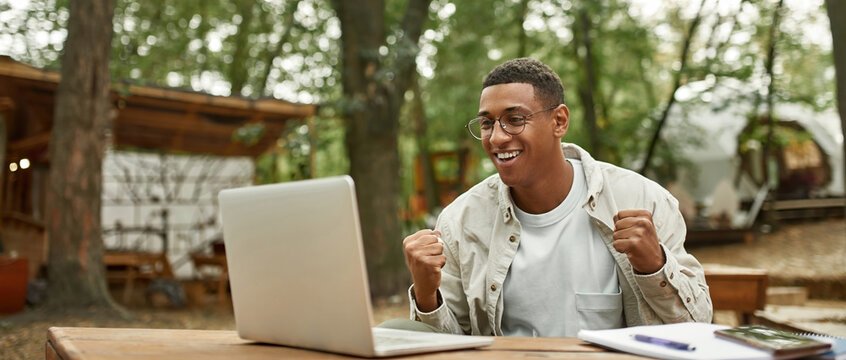 Smiling young african american man holding fists