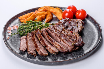 Delicious juicy fresh beef steak with spices and herbs on a white background