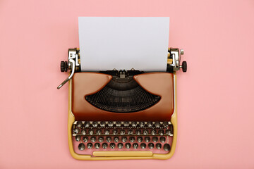 Vintage typewriter with sheet of paper on pink background, top view