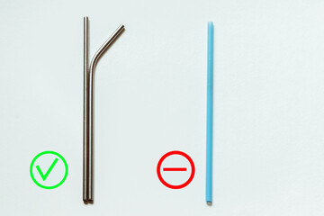 Reusable metal straws for drinks and disposable blue plastic straws lie on a white background. Caring for the environment.
