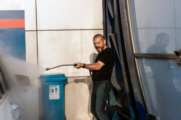 Man washing his car on self service car washing station