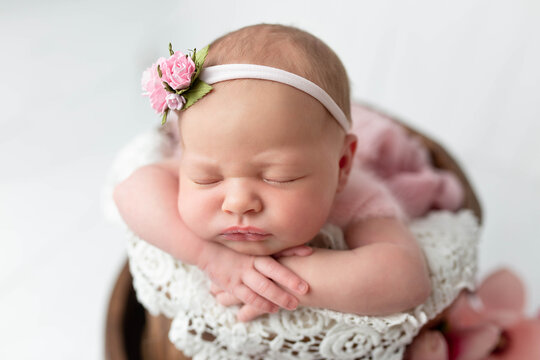 newborn baby girl with a flower on her head. first photo session of a newborn baby