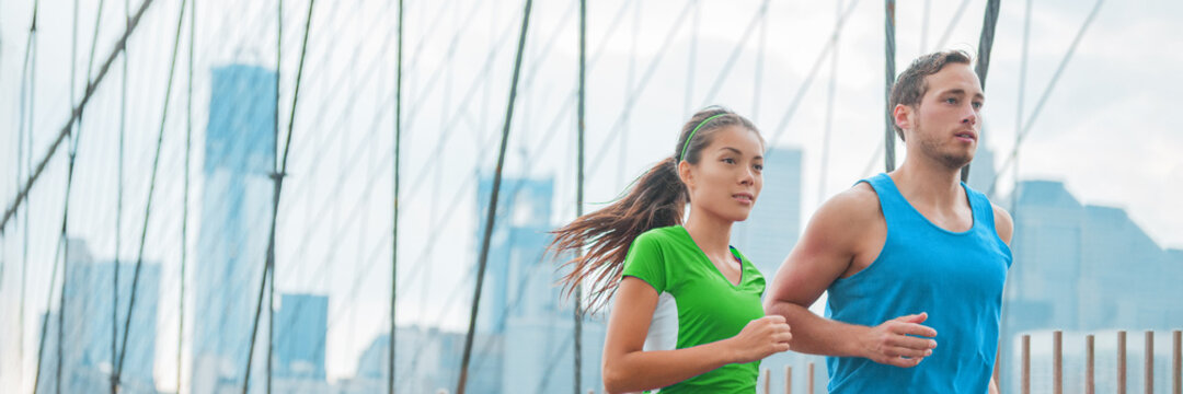 Athletes runners running on New York city Brooklyn Bridge for Marathon training, fitness workout of Asian woman and Caucasian man, interracial couple banner.
