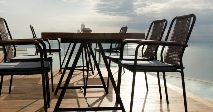 High end restaurant with empty tables, pool and panoramic view at the seascape from the mountain, luxury dining.