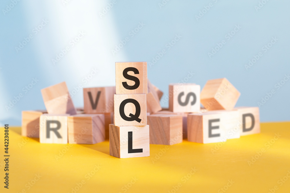Poster wooden cubes with letters sql arranged in a vertical pyramid, yellow background