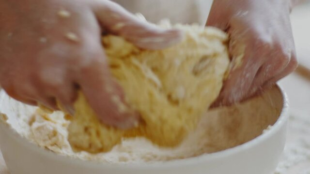 Unrecognizable woman chef baker housewife kneading dough in bowl in home bakery kitchen. Close-up female hands preparing making cooking homemade donuts wheat white bread from flour. Food cook concept