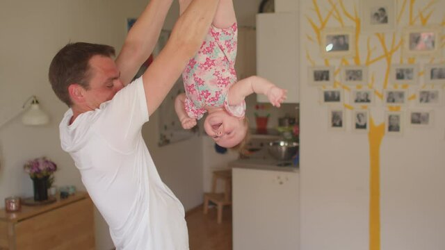 Dad doing dynamic gymnastics with a child at home. Baby yoga and healthy lifestyle. Family tree background.