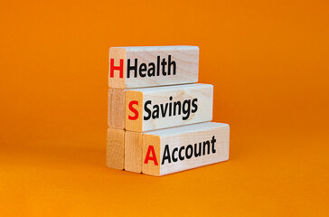 HSA health savings account symbol. Concept words HSA health savings account on wooden blocks on a beautiful orange background. Business and HSA health savings account concept.