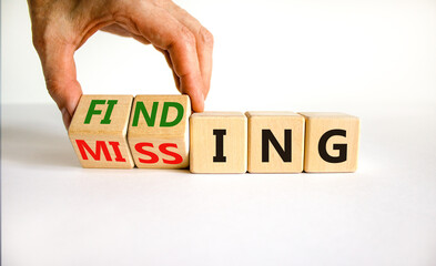 Finding or missing symbol. Businessman turns wooden cubes and changes the word missing to finding....