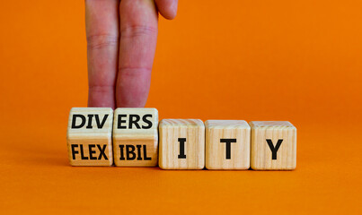 Diversity and flexibility symbol. Businessman turns wooden cubes and changes the word flexibility to diversity. Beautiful orange background. Business, diversity and flexibility concept. Copy space.